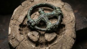 Cruz de rueda medieval de bronce del siglo X hallada en Brandeburgo que encaja en un molde de fundición antiguo.